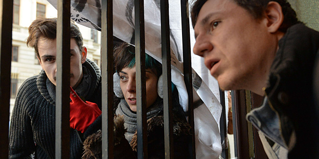 Protesters against the Rosia Montana gold mining using cyanide adress to outside ones as they occupy the People Advocate's headquarters in Bucharest December 10, 2013. Around 100 people entered the People Advocate's office, asking him to take action against a draft law clearing the way for a controversial open-cast gold mine planned by Canada's Gabriel Resources in Rosia Montana, a village in the heart of Transylvania. AFP PHOTO / DANIEL MIHAILESCU