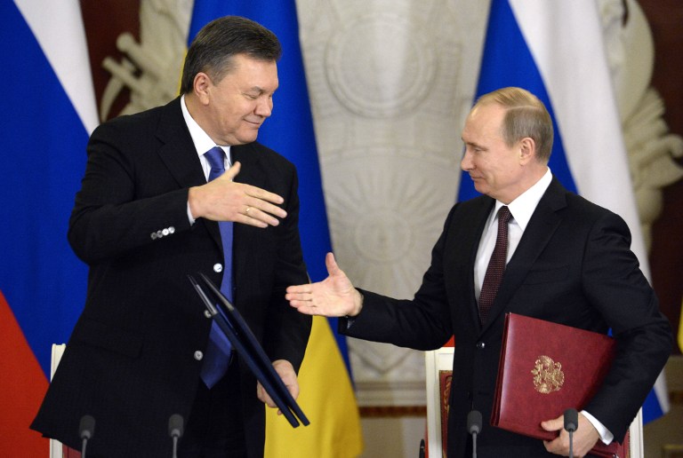 Russia's President Vladimir Putin (R) and Ukrainian President Viktor Yanukovych shake hands after signing documents during their meeting in the Kremlin in Moscow, on December 17, 2013.  Putin said that the state energy companies of Russia and Ukraine had signed an amended agreement slashing the price Moscow charges its cash-strapped neighbour for natural gas.    AFP PHOTO / ALEXANDER NEMENOV
