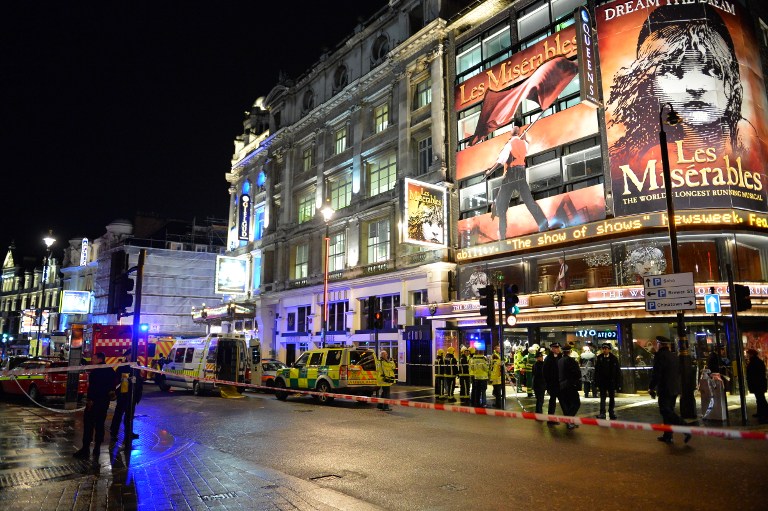 Police and emergency services personnel assist in operations behind a cordon following a ceiling collapse at a theatre in Central London on December 19, 2013.   The ceiling of a top London theatre collapsed on the audience during a performance Thursday, causing what police said was an unknown number of casualties and leaving terrified theatregoers covered in blood and dust.  AFP PHOTO/LEON NEAL