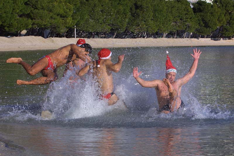 Makarska, 241213.Veselo drustvo koje je odlucilo zaigrati picigin na makarskoj plazi Donja Luka. Prigodno opremljeni crvenim kapicama i pjenuscem opusteno su zaigrali u moru temperature oko 17 stupnjeva dok su na se suncu ugrijali na dvadesetak.Foto: Ivo Ravlic / CROPIX