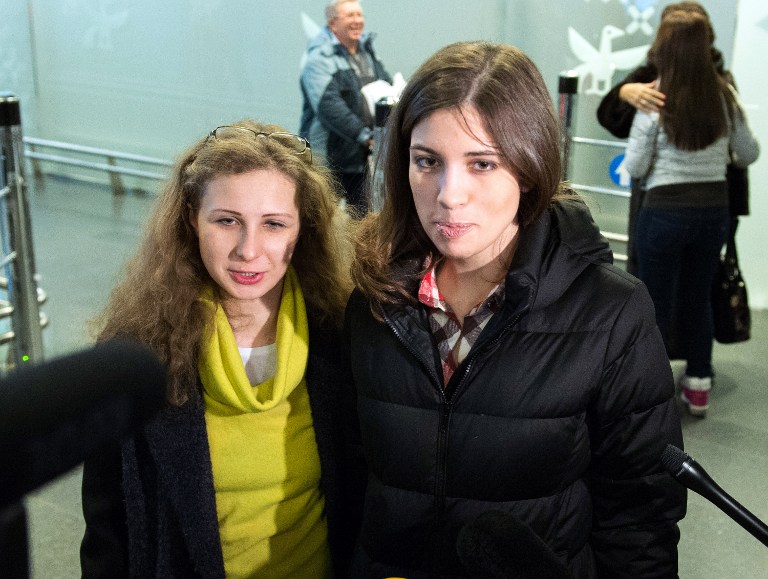 Two members of Russian punk group Pussy Riot, Nadezhda Tolokonnikova (R) and Maria Alyokhina (L), speak with journalists upon their arrival in Moscow on December 27, 2013. The two freed members of the anti-Kremlin punk group arrived back in Moscow after reuniting in Siberia, ahead of holding their first news conference since their release earlier this week. Their release two months early from their two-year prison terms came after an amnesty backed by Russian President Vladimir Putin. AFP PHOTO/DMITRY SEREBRYAKOV