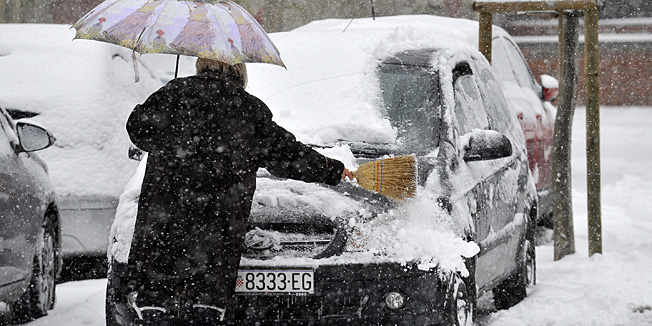 Zagreb, 250313.Vukovarska ulica.Obilni snijeg koji danas nemilosrdno pada u Zagrebu prouzrocio je prometne probleme i zastoj u prometu.Na slici: ciscenje snijegom zametenug auta.Foto: Damir Krajac / CROPIX