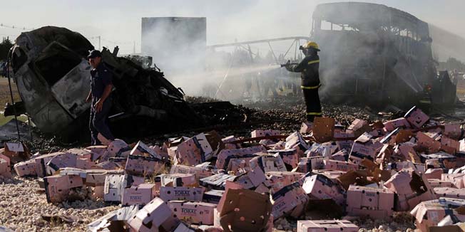 Firefighters extinguish the fire of the wreckage of a bus and a truck that collided head-on after the truck --which was allegedly stolen-- went the wrong way in Route 7, in San Martin, Mendoza, 1,000 km west of Buenos Aires, on February 7, 2014. At least fourteen people died in the crash.     AFP PHOTO / NA - Delfo Rodriguez   ARGENTINA OUT ---  RESTRICTED TO EDITORIAL USE - MANDATORY CREDIT 