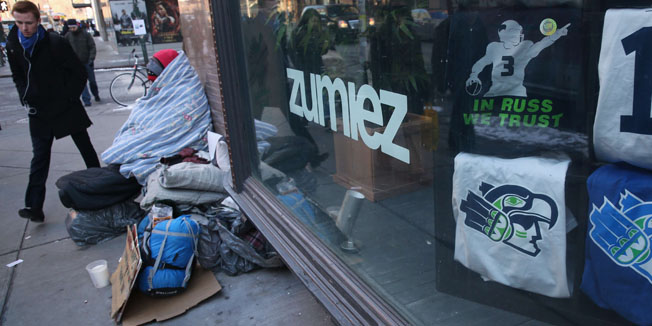 NEW YORK, NY - JANUARY 29: Seattle Seahawks clothing is advertises for sale as a homeless man bundles up against the cold on January 29, 2014 in New York City. Temperatures in New York City edged up over 20 degrees Wednesday as a cold wave continued to grip the country.   John Moore/Getty Images/AFP== FOR NEWSPAPERS, INTERNET, TELCOS & TELEVISION USE ONLY ==