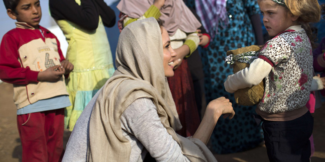 A handout picture made available by the United Nations High Commission for Refugees (UNHCR) on February 24, 2014 shows US actress and UNHCR Special Envoy Angelina Jolie talking to a young Syrian refugee on February 23, 2014 at a refugee camp near the Lebanese village of Zahle in the Bekaa valley. Jolie was on a trhee-day visit to Lebanon. AFP PHOTO /HO /UNHCR/A.MCCONEELL== RESTRICTED TO EDITORIAL USE - MANDATORY CREDIT 
