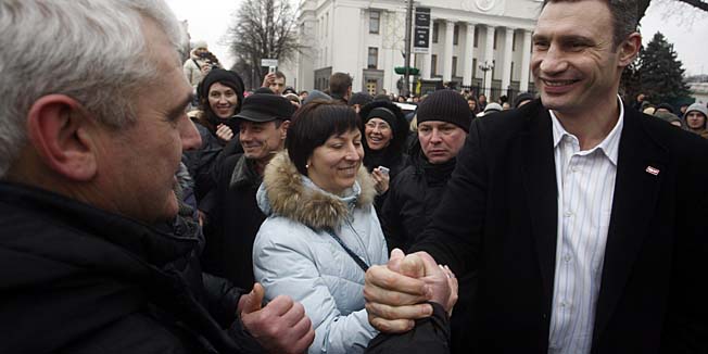 A man shakes hands with Vitali Klitschko (R), head of the UDAR (Punch) party, in front of the Ukrainian parliament in Kiev on February 23, 2014. A new era dawned in Ukraine on February 23 when parliament appointed a pro-Western interim leader after impeaching a defiant president Viktor Yanukovych, whose whereabouts remain a mystery following a week of carnage after months of mostly peaceful protests. AFP PHOTO/ YURY KIRNICHNY