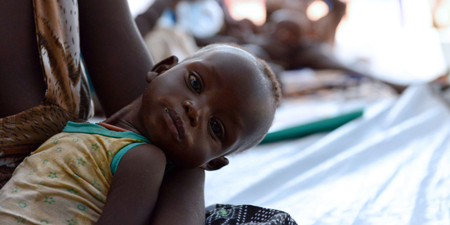 A mother waits with her child for treatment at the Medecins Sans Frontieres (MSF) hospital in Juba, on February 22, 2014. The World Health Organisation has launched on February 22, 2014 a vast vaccination campaign against cholera in the South Sudanese refugee camps, as an estimated 900 000 people have been displaced by the ongoing clashes in the country. AFP PHOTO/ CHARLES LOMODONG