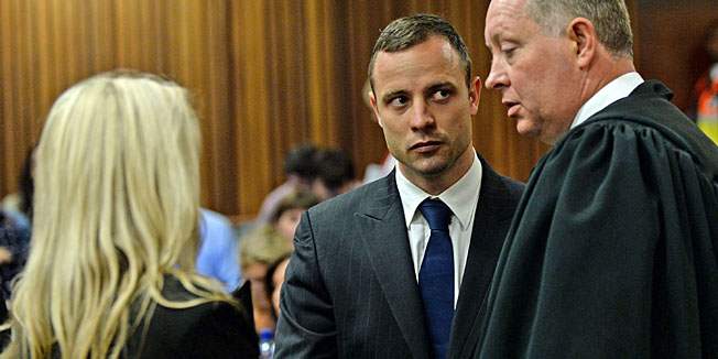 South African Paralympic athlete Oscar Pistorius (C), accused of murdering his girlfriend, looks on before court proceedings on the second day of his trial at the North Gauteng High Court in Pretoria, South Africa, on March 4, 2014. Lawyers for Paralympian Oscar Pistorius will on March 4 resume a searing cross-examination of a key witness at his murder trial who claims to have heard screams, then shots, as his girlfriend was killed. The second day of Pistorius's trial for the Valentine's Day killing of Reeva Steenkamp will begin with lawyer Barry Roux redoubling efforts to pick apart the prosecution's premier witness.  AFP PHOTO / POOL / ANTOINE DE RAS