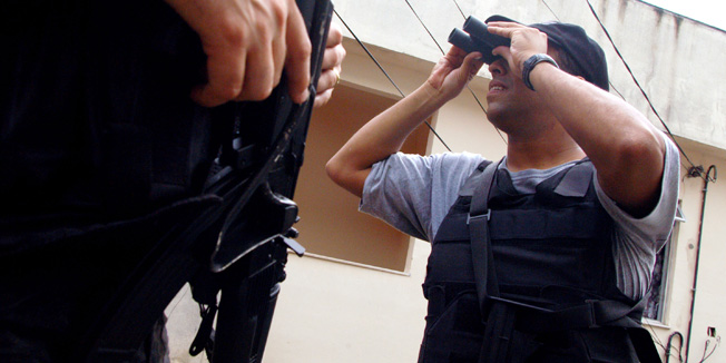 RIO DE JANEIRO, BRAZIL - MAY 29:  Brazilian federal police agents patrol Morro do Borel shantytown while giving security to police experts investigating the alleged execution of four of the shantytown's residents by Rio's military police May 29, 2003 in Rio de Janeiro, Brazil. Witnesses allege the four were shot by police officers, who suspected they were drug dealers, before they were able to show the police officers their ID documents. Already used to living in a city with one Brazil's highest crime rates, Rio's residents are terrorized with a surge in violence since the beginning of the year, with a series of business shutdowns, bombings and gun battles promoted by the city's drug dealers, who control most of Rio's shantytowns. The state police, under armed, underpaid, poorly trained and riddled by corruption and accusations of human rights abuses has been ineffective in controlling the wave of violence. To control the situation and to fight organized crime, the federal government has devised a National Internal Security Plan. (Photo by Andre Vieira/Getty Photo)