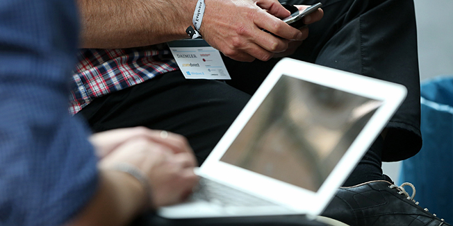 BERLIN, GERMANY - MAY 06:  Participants work on a smartphone and laptop computer in between conferences on the first day of the re:publica 2013 conferences on May 6, 2013 in Berlin, Germany. Re:publica, a three-day-event, brings together bloggers and digitial media professionals for a series of conferences on affecting social, political and economic change through the Internet.  (Photo by Sean Gallup/Getty Images)