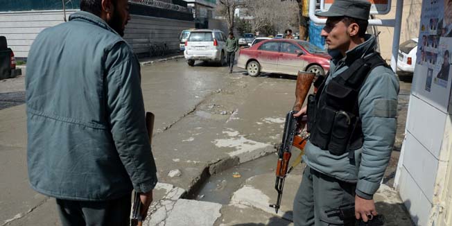 Afghan policemen stand alert at the site of an attack on a foreign national who was shot in the head and killed in Kabul on March 11, 2014.  A gunman shot dead a Swedish-British journalist in central Kabul, officials told AFP, a rare daylight murder of an expatriate in a city often hit by Taliban suicide attacks.  AFP PHOTO/SHAH Marai