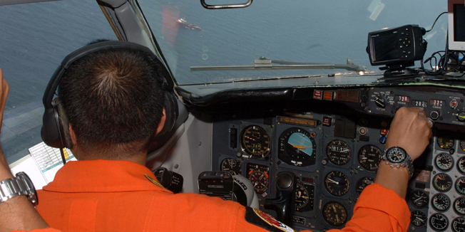 This handout photograph released by the Indonesian Air Force on March 12, 2014 shows the pilot aboard an Indonesian Air Force military surveillance aircraft on March 11 over the Malacca Strait, a passageway between Indonesia and Malaysia, searching for the missing Malaysia Airlines flight MH370.   The search for a missing Malaysian jet swung northwest towards the Andaman Sea on March 12, far from its intended flight path, exposing Malaysia to mounting criticism that its response was in disarray.   AFP PHOTO / INDONESIAN AIR FORCE  ------EDITORS NOTE ------ RESTRICTED TO EDITORIAL USE - MANDATORY CREDIT 
