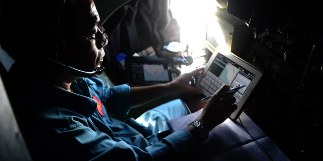TOPSHOTSA pilots on board a Vietnamese Air Force Russian-made AN-27 aircraft uses a tablet during a search flight over Vietnam's southern sea aimed at finding the Malaysia Airlines' missing flight MH370 on March 14, 2014. The needle-in-a-haystack hunt for the missing Malaysian airliner spread to the vast Indian Ocean after the White House cited 