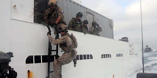 An image released by the Navy Media Content Service (NMCS) and downloaded from the US Navy website on March 17, 2014, shows US Navy Seals assigned to a west coast based SEAL Team debark a hostile vessel off the coast of San Diego on May 23, 2012. Naval Special Warfare Boat Team (SBT) 12 assisted in the operation by providing small boat insertion and extraction to and from the boarded vessel. US Navy Seals have boarded and taken control of a North Korea-flagged tanker that had loaded crude oil at a port held by rebels in eastern Libya, the Pentagon said on March 17, 2014.  AFP PHOTO/HO/US NAVY/ Kristopher Kirsop   == RESTRICTED TO EDITORIAL USE - MANDATORY CREDIT 