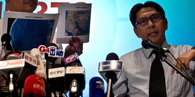 Malaysia's Minister of Defence and Acting Transport Minister, Hishammuddin Hussein (L) looks at maps as Director General of Civil Aviation Department (DCA) Azharuddin Abdul Rahman (R) answers questions during a press conference at a hotel near Kuala Lumpur International Airport in Sepang on March 17, 2013. An investigation into the pilots of missing Malaysia Airlines flight 370 intensified on March 17 after officials confirmed that the last words spoken from the cockpit came after a key signalling system was manually disabled.     AFP PHOTO/ MANAN VATSYAYANA