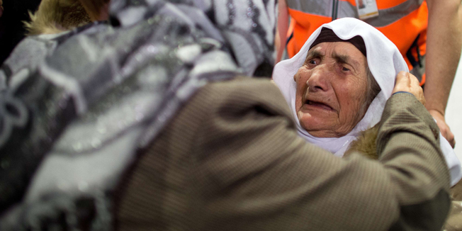 Sabria Khalaf (R), 107 years old Syrian refugee, is hugged by a relative after her arrival at the airport in Duesseldorf, western Germany, on March 17, 2014. Khalaf was welcomed by family members who are already living in Germany.   AFP PHOTO / DPA / FEDERICO GAMBARINI / GERMANY OUT