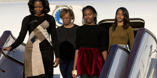 US First Lady Michelle Obama (front L), her daughters Sasha (2nd R), Malia (back R) and Michelle Obama's mother Marian Robinson (2nd L) exit their plane upon arrival at Beijing's Capital International Airport on March 20, 2014. Michelle Obama arrived in Beijing with her mother and daughters to kick off a seven-day, three-city tour where she will focus on education and cultural exchange.     AFP PHOTO / POOL / Alexander F. Yuan