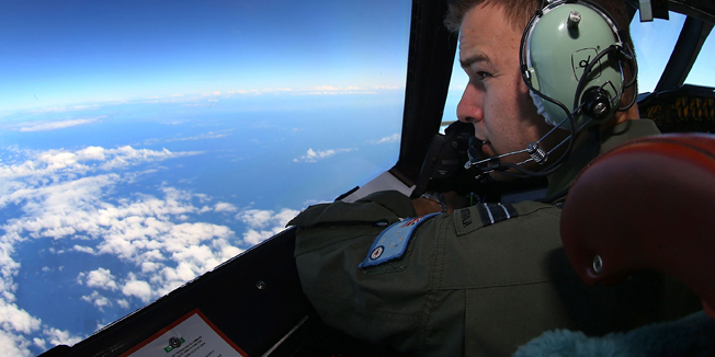 TOPSHOTSRAAF Flight Lieutenant Russell Adams looks out from the cockpit of a AP-3C Orion during a search mission for missing Malaysia Airline flight MH370 in the Southern Indian Ocean on March 26, 2014.  The race to find wreckage from flight MH370 took on new urgency on March 27, 2014, ahead of forecast bad weather after satellite images of more than 100 floating objects sparked fresh hopes of a breakthrough. AFP PHOTO / POOL / Paul KANE
