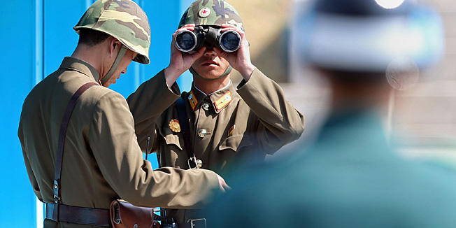 A North Korean soldier (C) looks through binoculars towards the South side at the truce village of Panmunjom in the Demilitarized zone (DMZ) dividing the two Koreas on April 13, 2013. The Korean peninsula has been engulfed by escalating military tensions and dire threats of nuclear war ever since North Korea conducted a rocket test last December and a nuclear test in February. REPUBLIC OF KOREA OUT  NO ARCHIVES  NO INTERNET    RESTRICTED TO SUBSCRIPTION USE     AFP PHOTO/YONHAP
