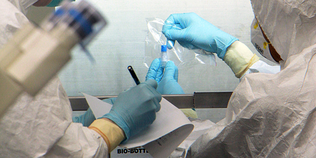 This handout photo taken and released by the Taiwanese Centers for Disease Control (CDC) on April 20, 2013 and received on April 21 shows health experts in full protective gear working on H7N9 viral specimens from China, at the National Influenza Center in Taipei.  Taiwan has received specimens of the H7N9 avian flu virus from China to help research the new strain, in what an official described Sunday as a landmark move in health cooperation.   AFP PHOTO / Taiwanese Centers for Disease Control (CDC)---EDITORS NOTE--- RESTRICTED TO EDITORIAL USE - MANDATORY CREDIT 