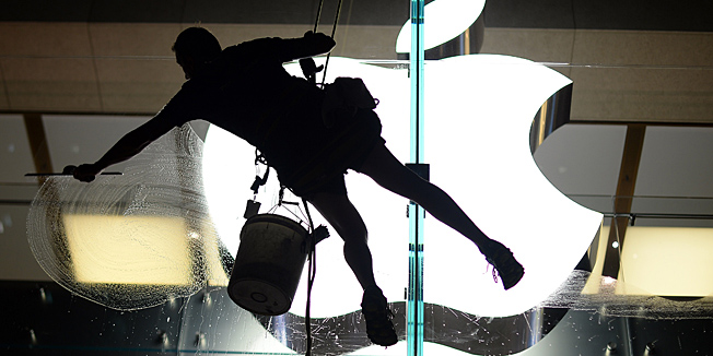 A worker leans to clean glass panels of the Apple store in the Central Business District of Sydney on Arpil 8, 2013.  Australia economy grew 0.6 percent in the three months to December as exports lifted, but analysts have warned of a subdued picture overall. AFP PHOTO / Saeed Khan