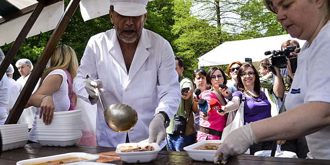 Zagreb, 010513.Proslava povodom Medjunarodnog praznika rada u parku Maksimir. Brojni Zagrepcani su posjetili Maksimir gdje su mogli besplatno  pojesti grah, prosetati se, veslati na jezeru, uzivati u prigodnom kulturnom programu i drugim aktivnostima. Na slici: Milan Bandic dijeli grah.Foto: Admir Buljubasic / CROPIX