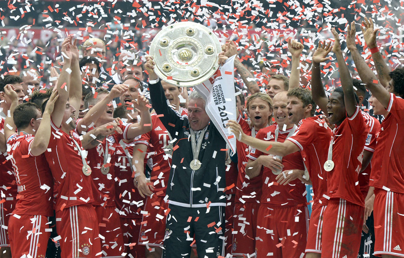 Bayern Munich's head coach Jupp Heynckes (C) holds the German football league champion's trophy while celebrating with his team their champion title, after winning 3:0 the German first division Bundesliga football match between Bayern Munich and FC Augsburg in Munich, southern Germany, on May 11, 2013. Munich were confirmed German league champions back on April 6, when they won the Bundesliga with a record six games left to play.AFP PHOTO / CHRISTOF STACHE
