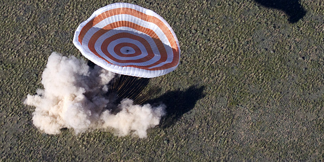 TOPSHOTSThe Russian Soyuz space capsule with US astronaut Tom Marshburn, Canadian spaceman Chris Hadfield and Russian cosmonaut  Roman Romanenko aboard  lands some 150 km (90 miles) southeast of the town of Zhezkazgan in central Kazakhstan on May 14, 2013.  Marshburn, Hadfield  and Romanenko returned today  to Earth aboard a Russian Soyuz-TMA capsule after a half-year mission to the International Space Station, Moscow mission control said. AFP PHOTO / POOL / SERGEI REMEZOV