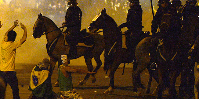 Demonstrators confront riot police officers after clashes erupted during a protest against corruption and price hikes, on June 20, 2013, in Rio de Janeiro as the FIFA Confederations Cup Brazil 2013 is being held in the country. Brazilians took to the streets again Thursday in several cities on a new day of mass nationwide protests, demanding better public services and bemoaning massive spending to stage the World Cup. AFP PHOTO / LLUIS GENE