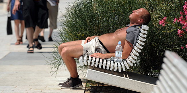 Split, 190613. U Splitu je u 12h izmjereno 32 stupnjeva Celzijevih. Od vrucine su neki potrazili spas u moru, a ostali posegnuli za napitcima i kremama za suncanje.Na slici: turisti na splitskoj rivi.Foto: Paun Paunovic / CROPIX