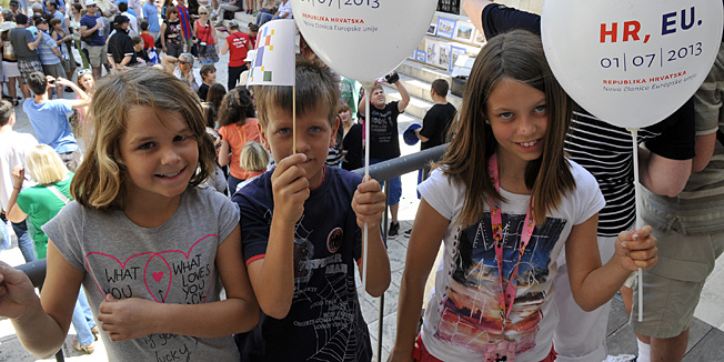 Split, 300613. Proslava ulaska Republike Hrvatske u Europsku uniju u Splitu je zapocela nizom dogadjanja. Turistima i Splicanima dijeljeni su prigodni baloni i zastavice, a splitski gradonacelnik je prigodno na standarac pokraj bivse gradske vijecnice na Pjaci podigao zastavu Europske unije.Na fotografiji i najmladji Splicani vesele se ulasku u Europsku uniju..Foto: Mario Todoric / CROPIX