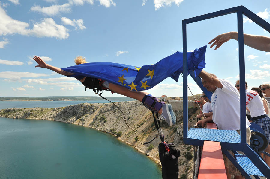 Maslenica, Zadar, 300613I ove godine su na otvaranju sezone bungee skokova s Maslenickog mosta skakali novinari i poznate osobe. Na skok se odvazio Kristijan Kike Curavic koji je dosao u pratnji svojih prijatelja Doris Pincic i njenog decka Borisa Rogoznice. Kako Hrvatska veceras postaje clanicom EU, s mosta se skakalo i sa prigodnom zastavom.Na fotografiji: bungee na Maslenickom mostu; hrvatska gimnasticarka Tina Erceg skocila je sa zastavom EU.Foto: Luka Gerlanc / CROPIX