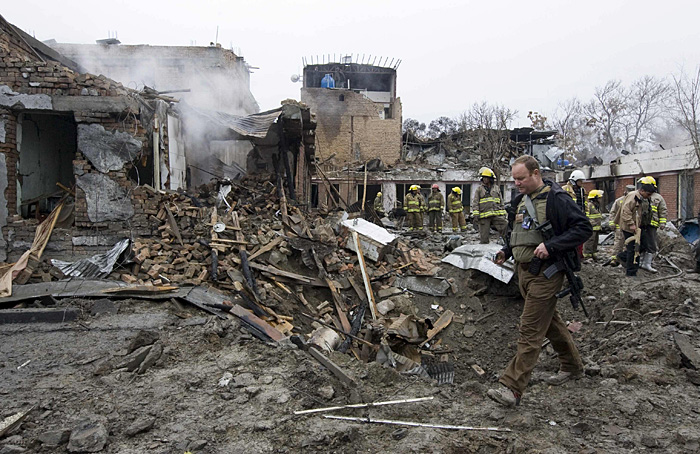 A foreign forensic expert looks for evidence at the site of a bomb blast in Kabul February 26, 2010. At least 14 people were killed and 32 wounded in Taliban attacks in Kabul on Friday, officials said, the latest audacious assault in the Afghan capital despite a renewed push against the insurgents. REUTERS/Shamil Zhumatov (AFGHANISTAN - Tags: CIVIL UNREST)