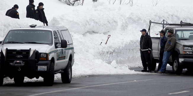 King County Sheriff's officers and other emergency officials work along Highway 2 near Stevens Pass ski resort in Skykomish, Wash., near where three skiers were killed in an avalanche Sunday, Feb. 19, 2012. The avalanche swept the three skiers about a quarter-mile down an out-of-bounds canyon at the popular resort. A fourth skier caught up in the slide was saved by a safety device, authorities said. (AP Photo/The Seattle Times, Erika Schultz)  MAGS OUT; NO SALES; SEATTLEPI.COM OUT; MANDATORY CREDIT