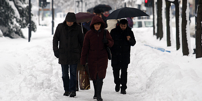 Zagreb, 150113.Trg Josipa Jurja Strosmayera.Obilni snijeg koji je prekrio zagrebacke ulice danas se s povecanjem temperature topio sto je stvorilo velike lokve kod pjesackih prijelaza te odrone snijega sa krovova zgrada. Na fotografiji: gradjani se probijaju kroz snijeg.Foto: Tomislav Kristo / CROPIX