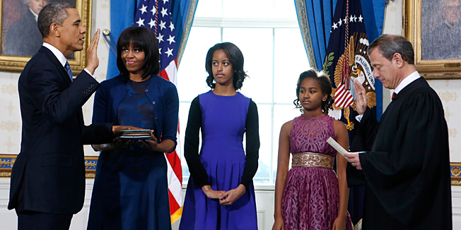 US President Barack Obama (L) takes the oath of office from US Supreme Court Chief Justice John Roberts as first lady Michelle Obama holds the bible and their daughters Malia (C) and Sasha (2nd R) look on in the Blue Room of the White House in Washington on January 20, 2013.  AFP PHOTO/Larry Downing/Pool