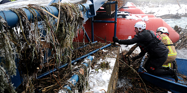 Karlovac, 290113.Vatrogasci, pripadnici Hrvatske gorske sluzbe spasavanja, policija, te radnici Cistoce i Zelenila u akciji su ciscenja ogromne kolicine drvenih naplavina zadrzanih na pontonskom mostu na rijeci Korani. Zbog velikog opterecenja most se iskrivio i na nekim mjestima ostetio.Na fotografiji: Ciscenje naplavina na pontonskom mostu.Foto: Robert Fajt / CROPIX