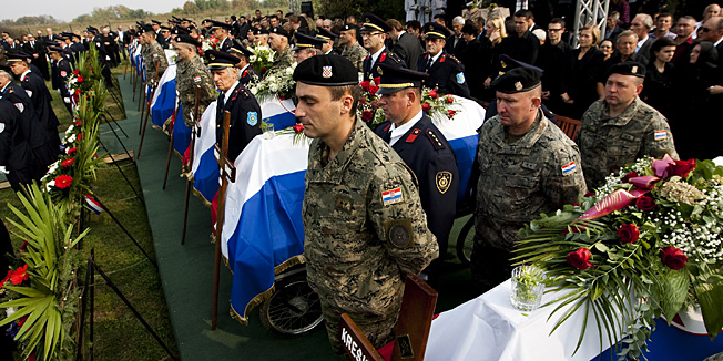 Sotin, Vukovar, 141013.Na mjesnom katolickom groblju u Sotinu zajednicki su ispraceni i pokopani posmrtni ostaci cetiri hrvatska branitelja i sedam civilnih zrtava eksumiranih u travnju 2013. iz masovne grobnice u Sotinu.Na ispracaju je bio i mnistar branitelja Predrag Matic a misu je vodio nadbiskup osjecko-djakovacki Djuro Hranic.Na fotografiji: ispracaj jedanaest zrtava ekshumiranih u masovnoj grobnici u Sotinu.Foto: Vlado Kos / Cropix