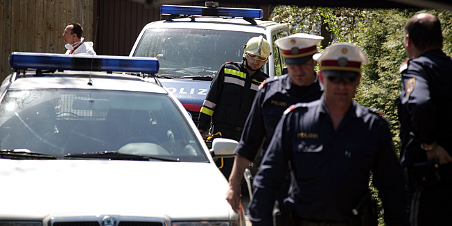 AMSTETTEN, AUSTRIA - MAY 02:  Policemen and members of the firebrigade are seen at the backside of the house, where a father imprisoned his daughter for 24 years and had seven children with her, seen on May 2, 2008 in Amstetten, Austria. According to police Josef F. kept his daughter Elizabeth, now 42, imprisoned in his basement and sexually abused her. Three of the children, now aged 5, 18 and 19, had never seen the light of day until the eldest was recently taken to hospital because of a severe illness.  (Photo by Johannes Simon/Getty Images)