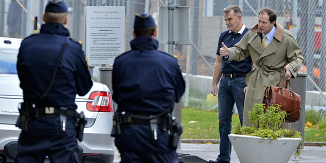 ADDING TO IDENTIFY AND NAME US AMBASSADOR - U.S. Ambassador to Stockholm, Mark Francis Brzezinski, centre, makes thumbs up gesture towards Swedish police and emergency workers arriving at the US embassy in Stockholm, Sweden, Wednesday Oct. 17, 2012, to investigate a suspicious package.   Police say the U.S. Embassy in Stockholm has been evacuated because of a letter with 