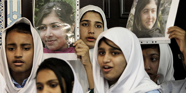 Pakistani students sing as they hold pictures of 14-year-old schoolgirl Malala Yousufzai, who was shot last Tuesday by the Taliban for speaking out in support of education for women, during a tribute at the Pakistani Embassy in Abu Dhabi, United Arab Emirates. Pakistan airlifted a 14-year-old activist who was shot and seriously wounded by the Taliban to the United Kingdom for treatment Monday, a move that will give her access to the specialized medical care she needs to recover and also protect her from follow-up attacks threatened by the militants. (AP Photo/Kamran Jebreili)