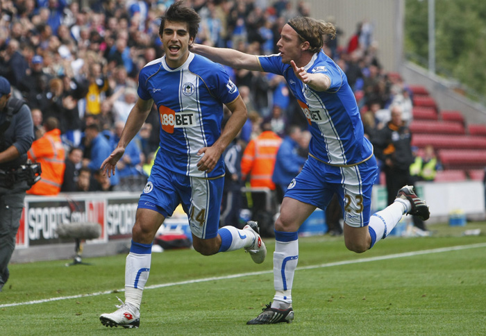 Wigan's Jordi Gomez, left, celebrates with team mate Ronnie Stam after scoring a goal against Wolverhampton during their English Premier League soccer match at DW Stadium, Wigan, England, Saturday Oct. 2, 2010. (AP Photo/Tim Hales) ** NO INTERNET/MOBILE USAGE WITHOUT FOOTBALL ASSOCIATION PREMIER LEAGUE (FAPL) LICENCE. CALL +44 (0) 20 7864 9121 or EMAIL info@football-dataco.com FOR DETAILS **