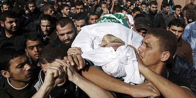 Palestinian mourners carry the body of Hamas militant Mohammed Al Qanoah during his funeral in Gaza City, Tuesday, Nov. 13, 2012. A Palestinian health official said Al Qanoah has died of wounds sustained in an Israeli airstrike on Saturday, Nov. 10, 2012. His death brings to seven the number of Gazans killed in Israeli airstrikes since Saturday. (AP Photo/Hatem Moussa)