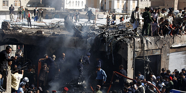 Army and police officers work at the scene of a plane crash in Sanaa, Yemen, Wednesday, Nov. 21, 2012. Yemeni security officials say a military plane has crashed during training over the capital, Sanaa, killing all 10 people on board. (AP Photo/Hani Mohammed)