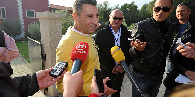 Pakostane, Zadar, 211112.Nakon sinocnjeg slavlja u rodnim Pakostanima, general Ante Gotovina povukao se sa suprugom Dunjom u svoju novoizgradjenu vilu pred kojom ga je cijelo jutro cekao velik broj novinara u nadi da ce im dati izjavu. General je okupljenim novinarima poslao kolace, a kasnije i nesto sira i kulena. Oko 14 sati Ante Gotovina je u pratnji supruge, odvjetnika Luke Misetica i jos nekoliko prijatelja izasao iz kuce i popricao sa okupljenim novinarima.Na fotografiji: Ante Gotovina s novinarima.Foto: Luka Gerlanc / CROPIX