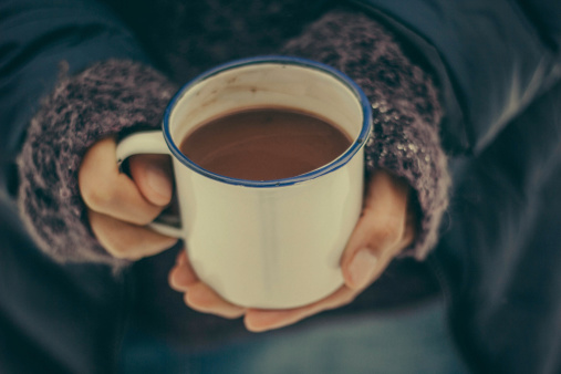 Hands holding a cup of hot chocolate in winter