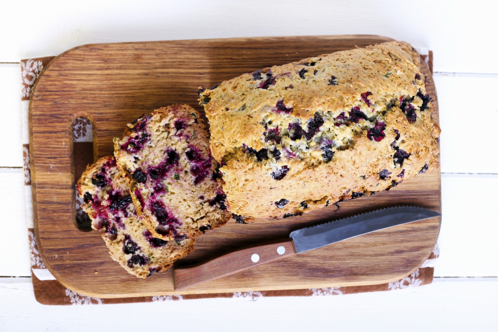 Berry, mint and spelt flour teacake, sliced on board, selective focus
