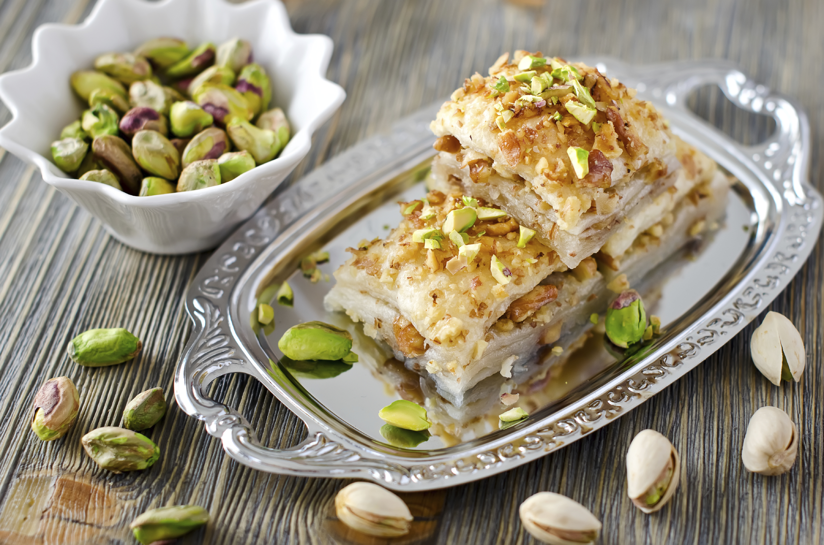 turkish traditional dessert with nuts and pistachios wooden background