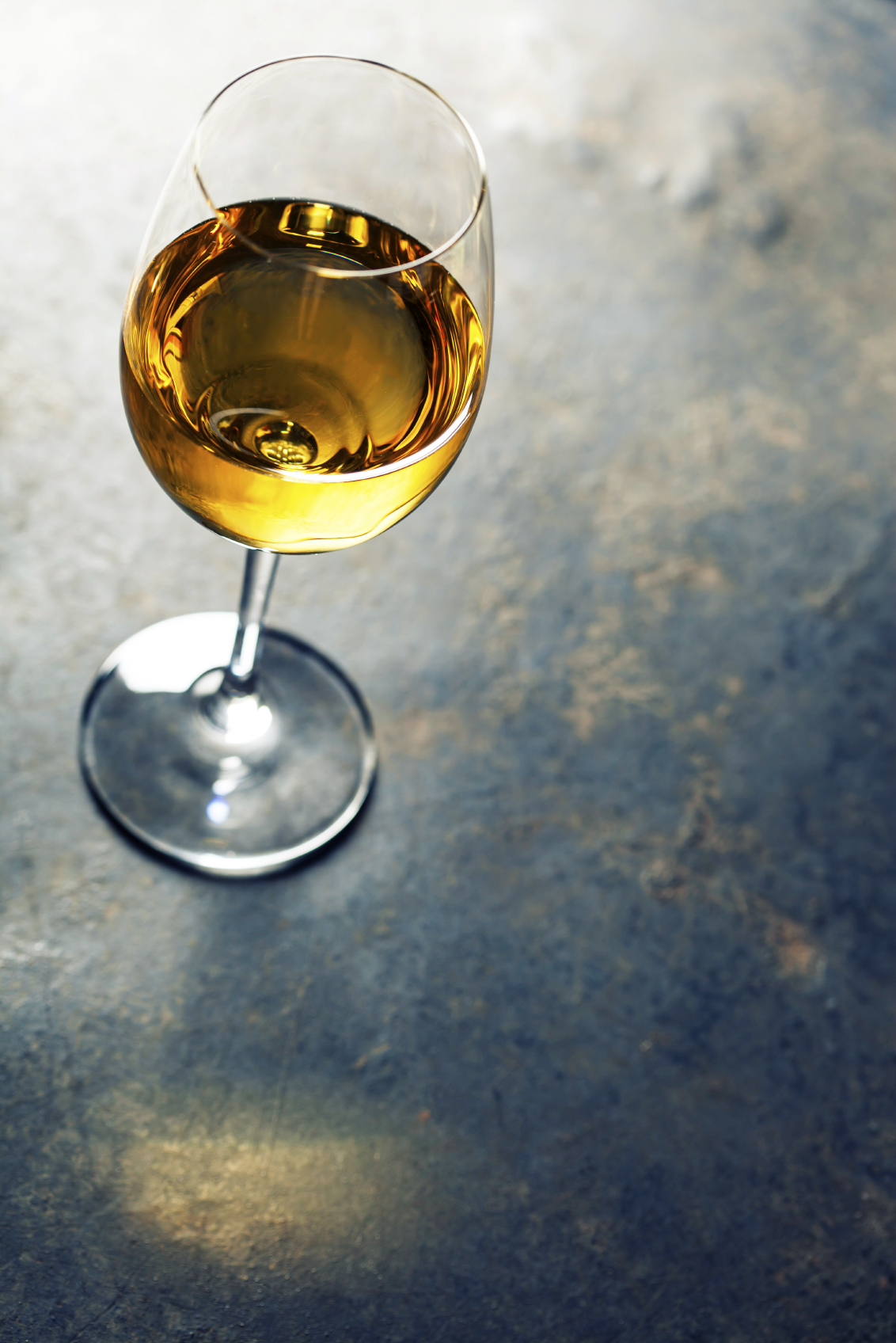 Glass of white wine on dark background