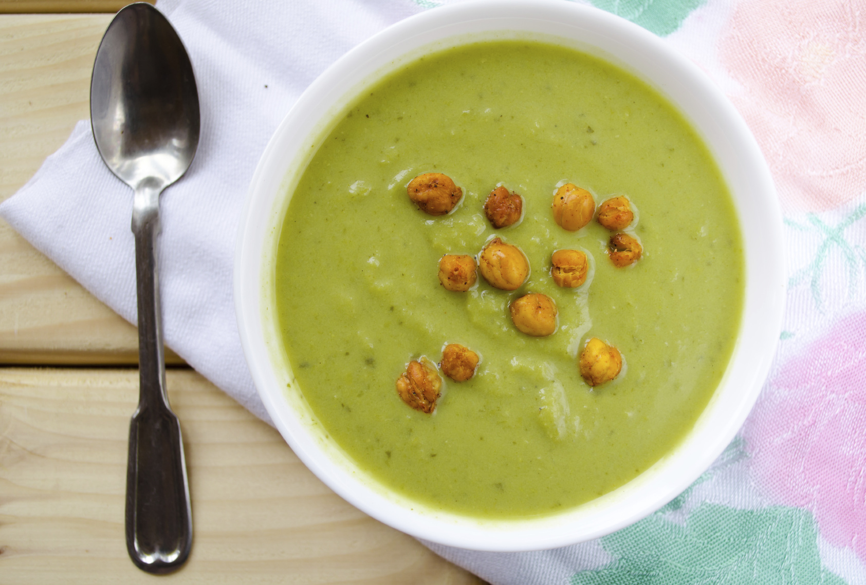 Green cream soup made of spinach, broccoli and peas, with grilled chickpeas